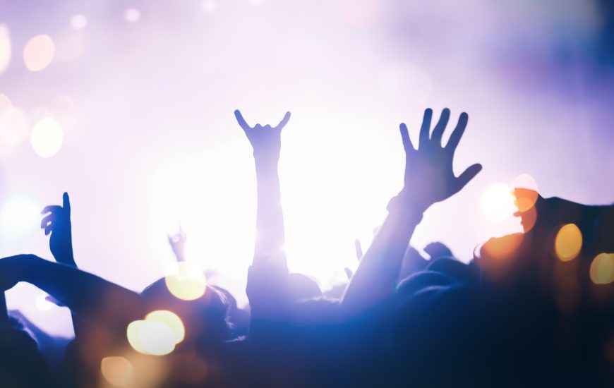 Manos facendo os cornos cara un escenario